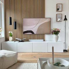 a living room with white furniture and wood paneling on the wall behind it is a large painting