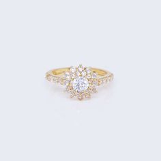 a yellow gold engagement ring with an oval diamond center and pave set diamonds around the band