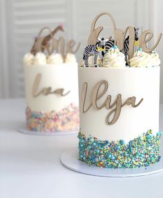 two decorated cakes sitting on top of a white table