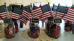 mason jars filled with red, white and blue confetti sitting on top of a table