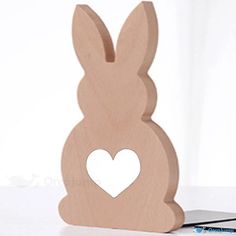 a wooden bunny with a heart cut out of it's back sitting on a table