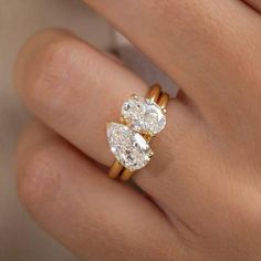 a woman's hand with two engagement rings on it