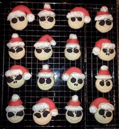 decorated cookies with santa hats and sunglasses on a cooling rack