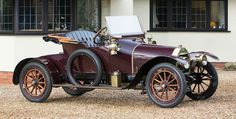 an old fashioned car parked in front of a building