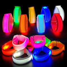 glowing bracelets and collars are shown in bright colors on a black background,