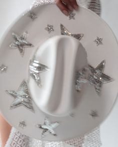 a woman holding a white plate with silver stars on it and an oval shaped object in the middle