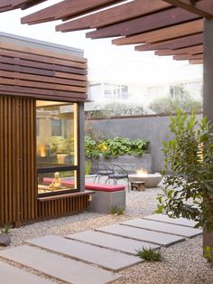 an outdoor room with wooden slats on the roof