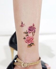 a woman's foot with pink roses and butterflies on the lower part of her leg