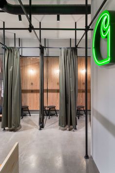 the interior of an office with green neon signs and drapes hanging from the ceiling