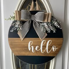 a door hanger that says hello on it with a bow and flowers in the center