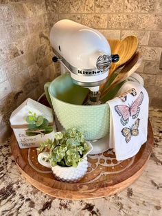 a kitchen mixer sitting on top of a wooden tray filled with dishes and utensils