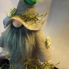 an odd looking stuffed animal with grass on it's head