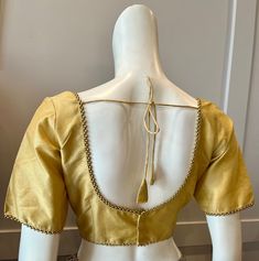 A golden color blouse Product details Fabric - silk blend Bust size 40" Waist 30" sleeve length 10" Can be tailored to fit 42" For extra charges Gold V-neck Blouse For Work, Traditional Gold V-neck Tops, Gold V-neck Blouse For Wedding, Elegant Gold Blouse For Workwear, Gold Long Sleeve Blouse For Work, Elegant Gold Blouse For Work, Fitted Gold Tops For Work, Gold Short Sleeve Tops For Formal Occasions, Gold Long Sleeve Office Blouse