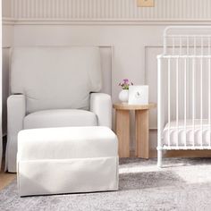 a baby's room with a crib, chair and footstool in it