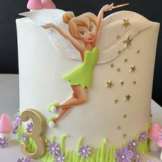 a birthday cake decorated with an image of a fairy on top and stars in the background