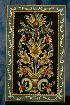 an ornately decorated wall hanging with flowers and swirls on black background, framed by blue velvet