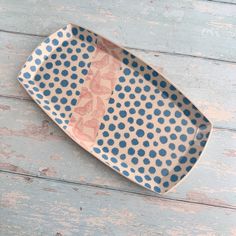 a blue and white polka dot dish on a wooden table