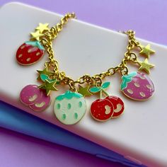 🌸Super cute fruity glitter shiny enamel charms on gold plated chain. strawberries and cherries colourful summer gift  💓Original design to my shop! super cute charm bracelet gift ❤️Bracelet lengths variations offered  18cm /7ins 20cm /8ins  Charm sizes vary approx 19mm x 18mm  If you want a specific size I can make just please message  💓lovely wrapped  🇬🇧UK  combined shipping means cheaper postage costs  🌟International shipping combined postage on! Cute Charm Bracelet With Dangling Charms As Gift, Cute Metal Charm Bracelet, Cute Dangle Charm Bracelet, Trendy Pink Jewelry With Fruit Design, Trendy Gold Jewelry With Fruit Design, Handmade Kawaii Gold Jewelry, Playful Jewelry With Fruit Design For Gift, Cute Fruit Design Dangle Jewelry, Handmade Gold Kawaii Jewelry