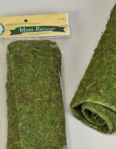 a roll of moss sitting on top of a white table next to a package of scissors