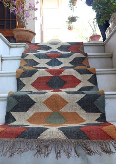 a carpeted stair case with potted plants on the top and bottom steps leading up