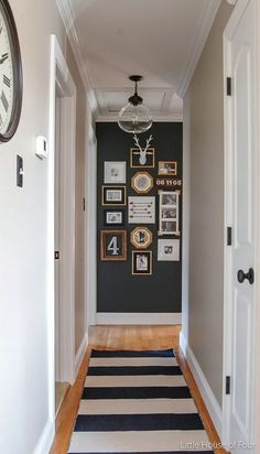 the hallway is decorated in black and white with pictures hanging on the wall above it