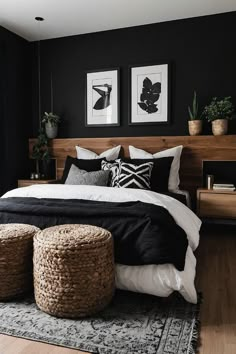 a bedroom with black walls, white bedding and two planters on the wall