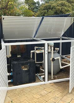 an outdoor water heater is shown in front of a fence