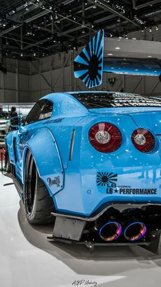 the rear end of a blue sports car on display