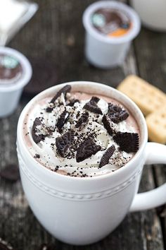 two cups of hot chocolate with whipped cream and oreo cookies