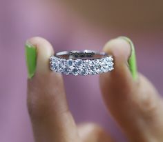 a woman's hand holding a diamond ring