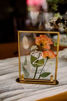 an image of flowers in a glass frame on a table