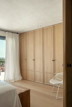 a bedroom with a bed, chair and sliding glass door that opens to the outside