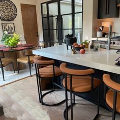 a kitchen island with four stools in front of it