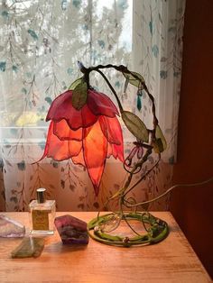 a table topped with a lamp next to a window