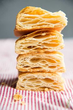 a stack of puff pastry sitting on top of a red and white striped table cloth