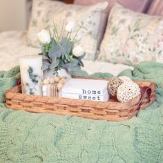 a tray with flowers and candles on top of a bed