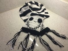 a crocheted hat with black and white yarn on it sitting on top of a counter