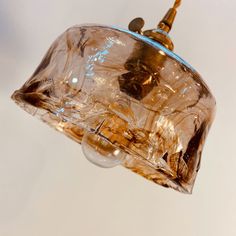 a clear glass light fixture hanging from a ceiling