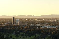 an aerial view of a city with trees and mountains in the backgrouds