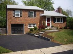 a brick house with two garages and landscaping