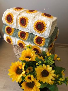 the sunflowers are next to some crocheted blankets on top of each other