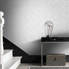 a table with a lamp on top of it next to a stair case and rug