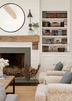 a living room filled with furniture and a fire place in front of a book shelf