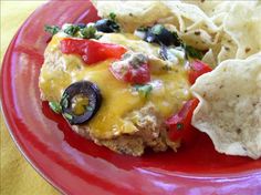 a red plate topped with an omelet and chips