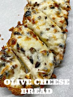 three slices of pizza sitting on top of a piece of paper with the words olive cheese bread