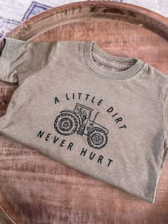 Adorable Tractor Tee for your little one. If you babe loves to play in the dirt this one is for you. A little dirt never hurt is printed in black around a tractor. Size Options are - 2T, 3T, 4T, 5T, Youth S, M, L and XL Runs True to size. Toddler shirts are 100% Cotton. Youth Shirts are 50% Cotton, 25% Polyester and 25% Rayon. There is a slight color difference between Toddler and Youth tees. Looking for more Graphic Tees? Click here ---> https://www.etsy.com/shop/GingerAndBabe?ref=seller-platfo Three Tractor Shirt, Toddler Boy Shirts Vinyl Farm, Cute Cricut Shirts Farm, Farming Birthday Party, Farm Birthday Shirt, Kids Shirts Design, Farm Kids, Farmer Shirt, Cute Shirt Designs