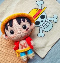 a crocheted doll laying next to a t - shirt with a pirate on it