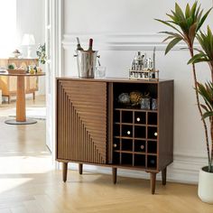 a wooden cabinet sitting next to a potted plant