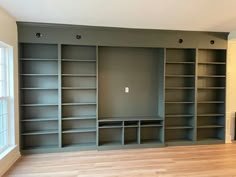 an empty living room with built in bookshelves