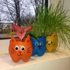 three cat planters sitting on top of a window sill